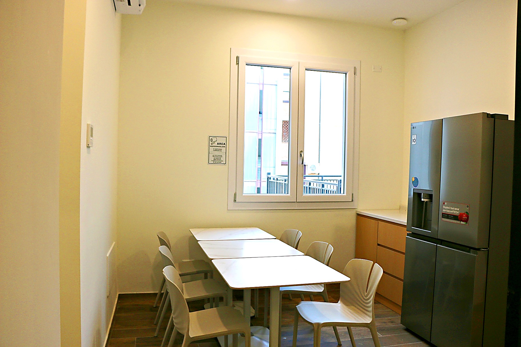 Dining area with white tables and chairs by the window