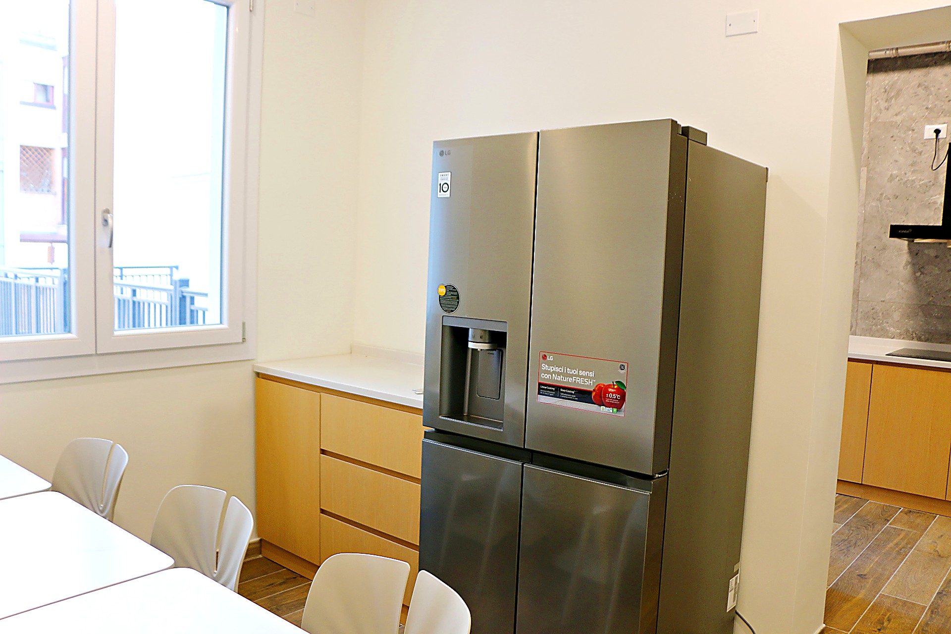 Large stainless steel fridge next to the dining area