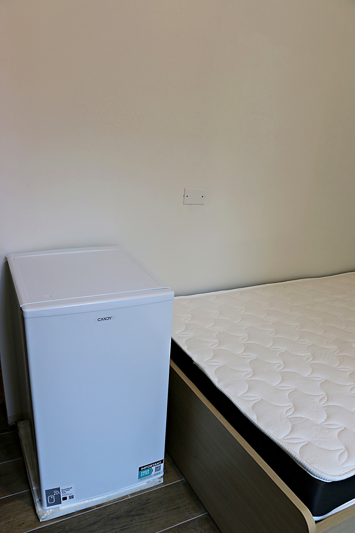 Single bed with mini-fridge alongside